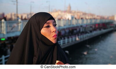 Woman dressed with black headscarf, chador eating, istanbul city. Woman  dressed with black headscarf, chador eating simit, | CanStock