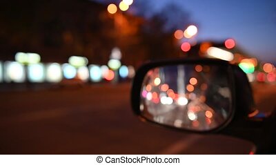 Driving at night. the view from the car on the side rearview mirror.  blurred city lights. 4k. Driving at night. the view from | CanStock