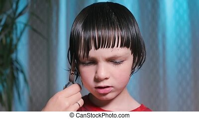 Close-up of hair cutting on the boy head. Close-up of hair cutting on the  boy's head. wet hair is cut in a straight line. | CanStock